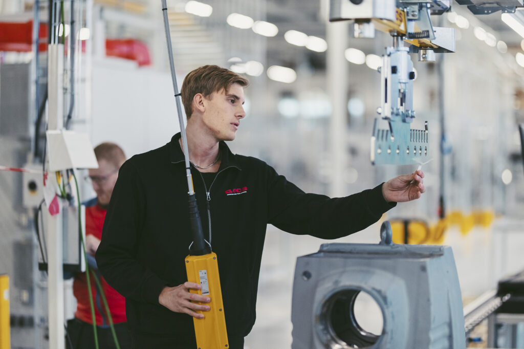 Tekniker justerar hängande drivenhet i produktion