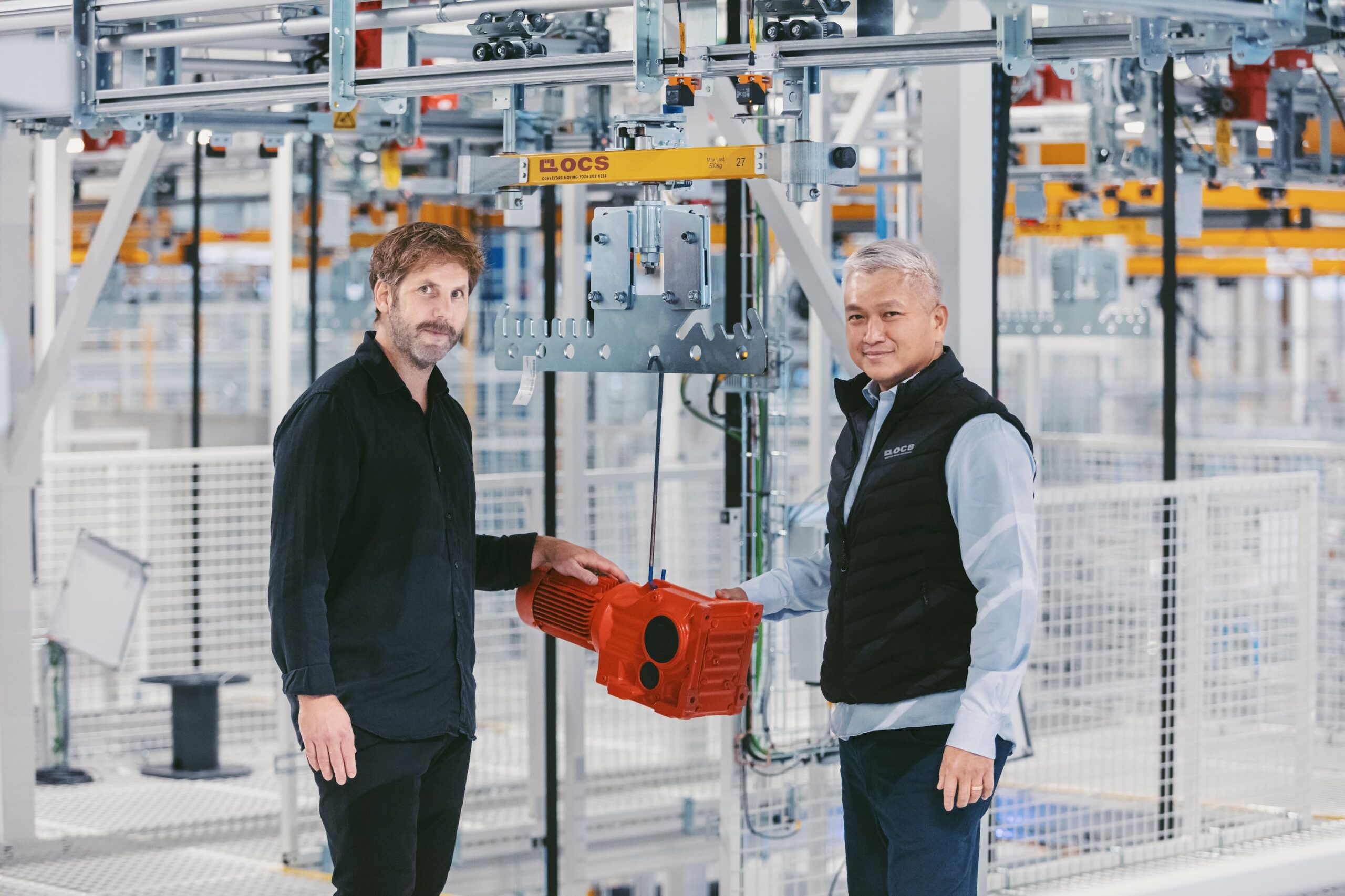 OCS-medarbetare överlämnar komponent vid conveyorsystem