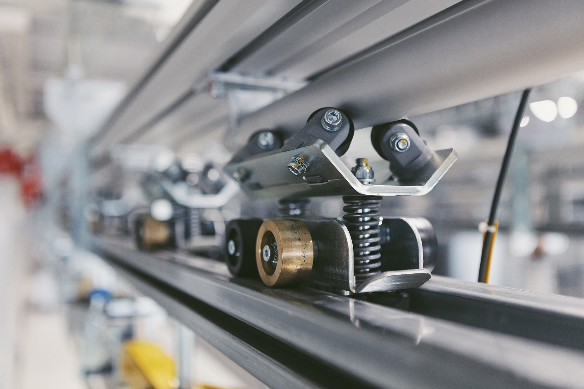 Close-up of an OCS trolley with friction wheel on the conveyor rail